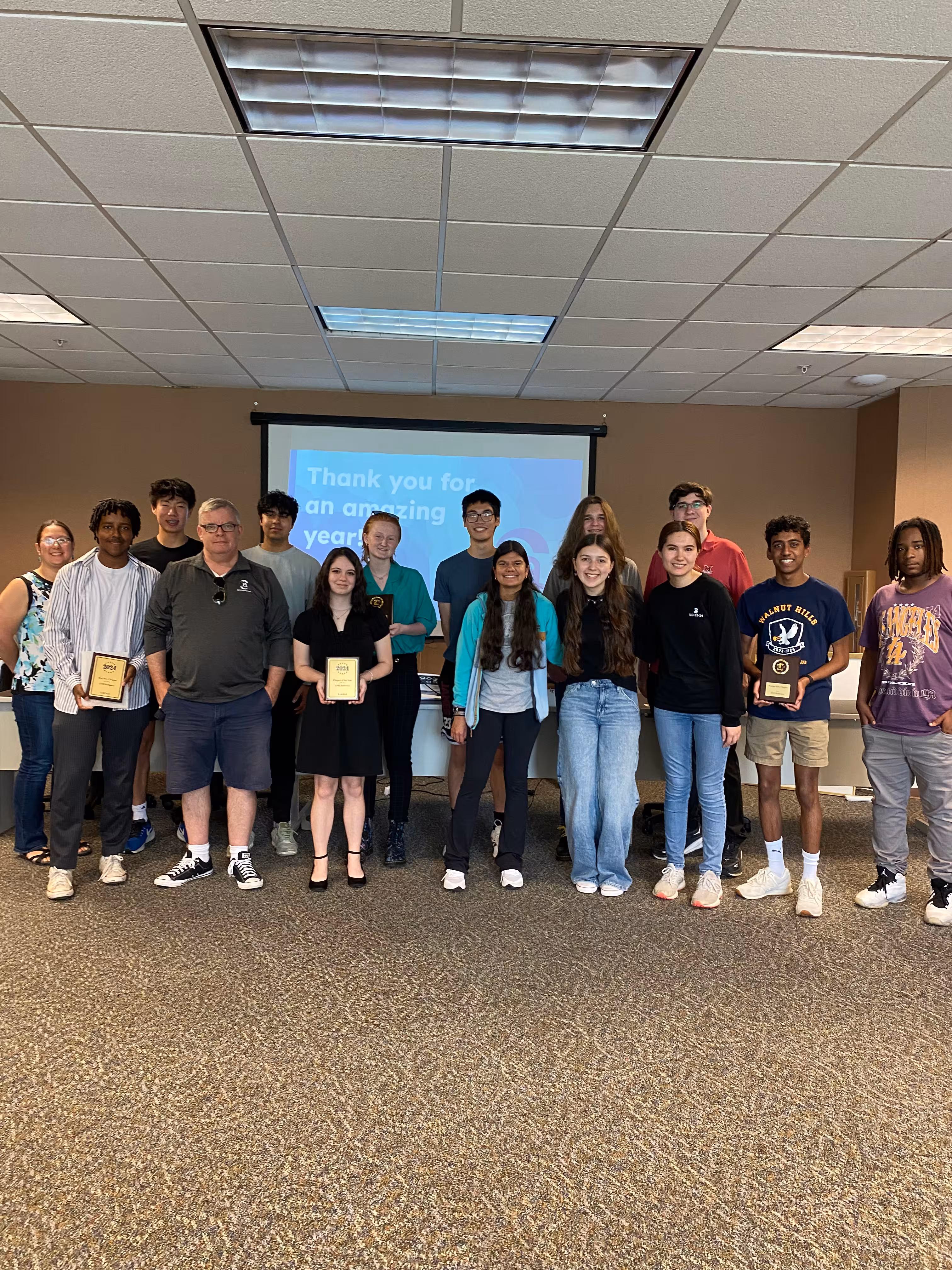 A photo of many students and professionals holding rewards.
